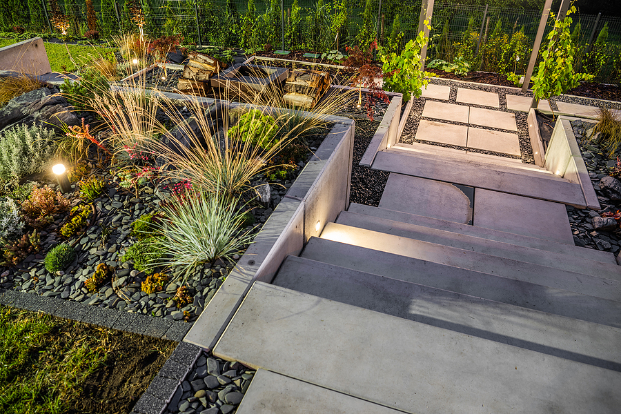 Terraced staircase with surrounding landscaping lit with landscape lighting installations - stairway leads to garden